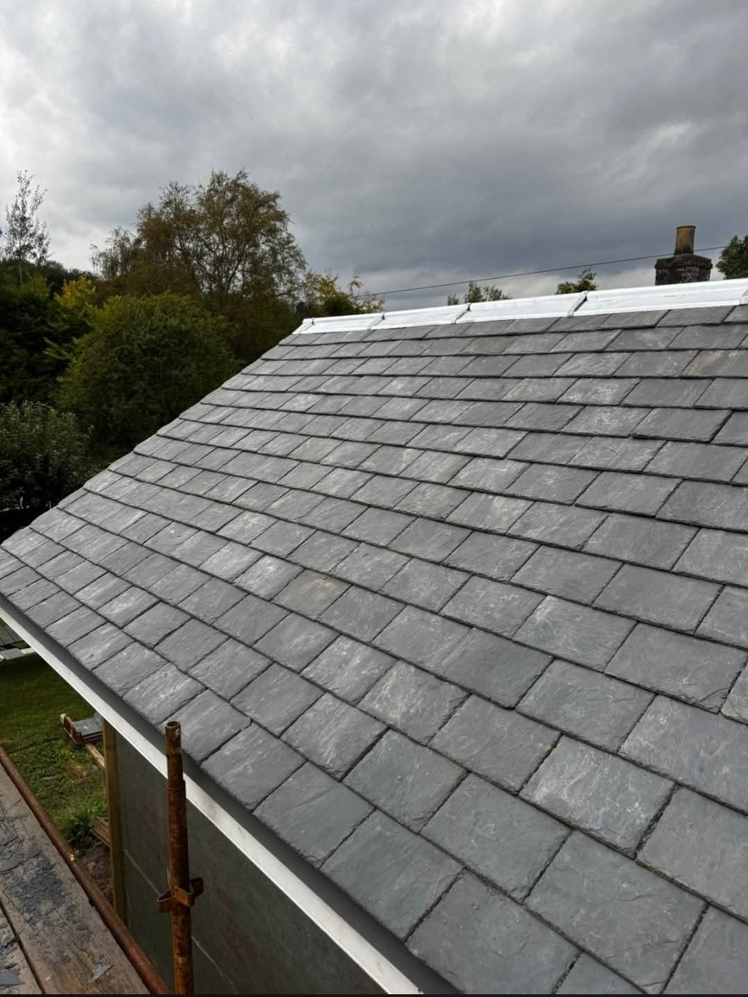 Freshly laid natural slate roof with new lead ridge flashing — Rossi Roofing project