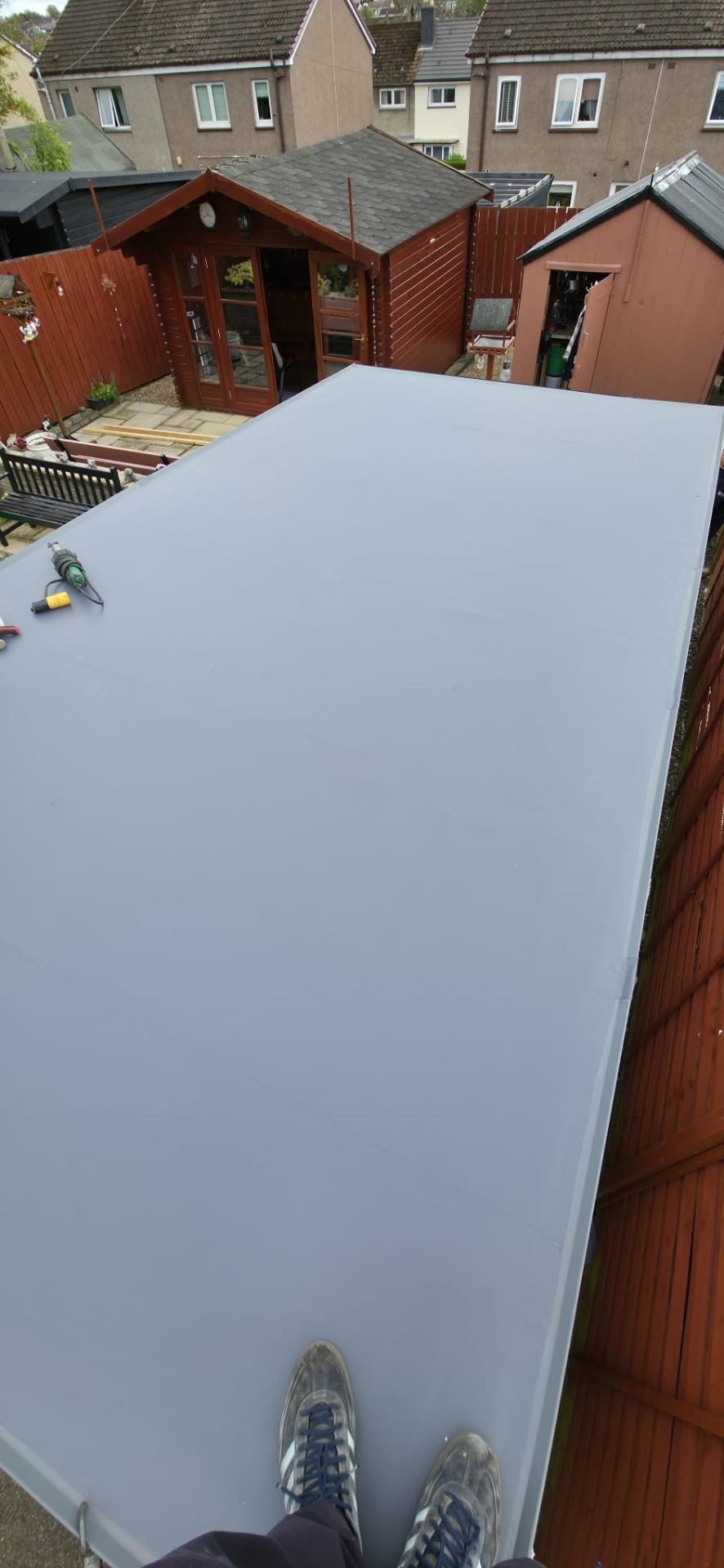 Newly installed grey single-ply flat roof, smooth and watertight — Rossi Roofing project